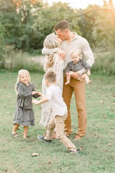 a family playing in the grass with their toddler's and older siblings