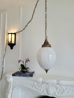 a lamp hanging from the ceiling next to a fireplace