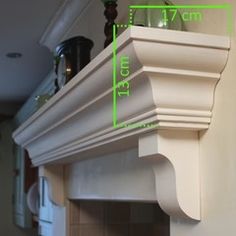 a white mantle with a clock on it's side and measurements for the fireplace mantel