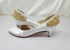 a pair of white high heel shoes with gold sequins