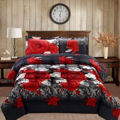 a bed with red and black flowers on it in a room next to two windows