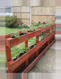 a wooden planter filled with lots of plants