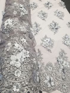 This Beautiful 3D Embroidered Satin Floral Pearl fabric is one of a kind. The fabric is backed with a mesh fabric and a gorgeous embroidered floral design, that gives off a 3D illusion. There are Pearls that have been stapled on to the fabric to give a gorgeous and eye catching design. Fabric is sold by the yard and if more than one yard is purchased, it will come in one piece. White satin is used for the backing of the fabric in images only, not included in the fabric. Width: 52" Uses: Apparel, Elegant Floral Embellished Lace Fabric, Fitted Organza Fabric With Intricate Embroidery, Fitted Organza Embroidered Fabric With Intricate Embroidery, Elegant Floral Embroidered Net Fabric, Intricately Embroidered Fitted Fabric For Mother Of The Bride, Fitted Embroidered Fabric For Mother Of The Bride, Floral Embellished Lace Embroidered Fabric, Floral Embellished Lace Fabric In Flower Shape, Lace Embroidered Floral Fabric