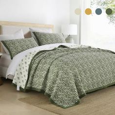 a bed with green and white comforters in a room