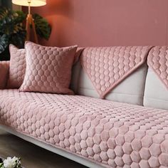 a living room with pink walls and couches in the corner, flowers on the coffee table