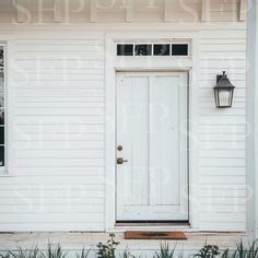 a white house with a light on the front door