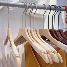 several wooden clothes hangers are hanging on a rack