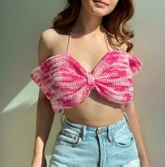 a woman wearing a pink crochet crop top