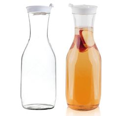 two different types of glass vases on a white background, one is filled with liquid and the other has fruit in it