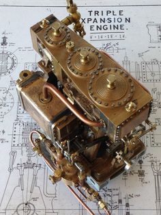 an old mechanical device sitting on top of a blueprint