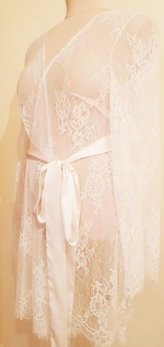 Off-white luxurious wedding robe, to add a perfect touch to your perfect and unique day. Only high quality fabrics and high finishing used for making the robe as neat as it can be. Please find the wedding robes collection here https://www.etsy.com/shop/LidiasBoutiqueDesign?ref=seller-platform-mcnav&section_id=25023222. For wedding dresses, please access https://www.etsy.com/shop/LidiasBoutiqueDesign?ref=seller-platform-mcnav§ion_id=23157290. For wedding tops and boleros, please access https: Fitted Lace Wedding Robe, Fitted Lace Robe For Wedding Night, Elegant Robe With Lace Sleeves For Wedding Night, Feminine Lace Wedding Robe, Elegant Lace Bride's Robe, Elegant Lace Bridal Robe, Elegant Wedding Night Gown With Delicate Lace, Feminine Lace Robe For Wedding Night, Feminine Lace With Lace Closure For Wedding