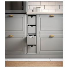 a kitchen with gray cabinets and white counter tops, gold pulls on the drawer handles