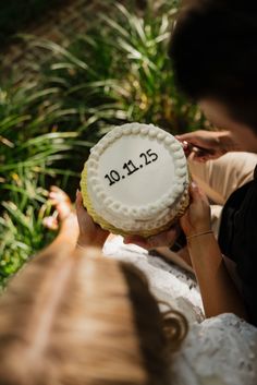 a woman holding up a cake with the words mr and mrs on it