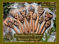 woodburned spoons with floral designs are on display in front of green leaves