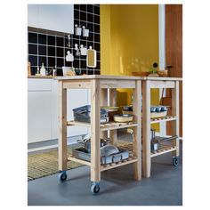 a kitchen island with lots of bowls and pans on it in front of a yellow wall