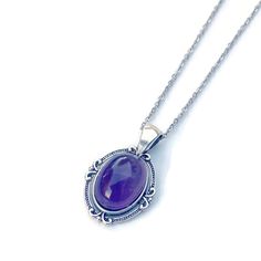 "Stunning genuine purple amethyst pendant in silver finish. This beautiful oval purple pendant showcases a lustrous purple polished and heat treated amethyst stone from the mines of Zambia. The amethyst stone is a rich purple shade is translucent and can vary depending on the light. Set in a delicate oval silver plated pewter pendant with attached bail, a sturdy stainless steel cable chain with lobster clasp ensures a secure fit. The last photo shows the design on the back of the pendant. Measurements(approx, see 3rd photo) Necklace Length:18\" Pendant:1.5\"x1\" Stone:18x13 mm Please Note: real amethyst stone, may have markings and color variations/inclusions due to the natural property of the amethyst gemstone." Classic Oval Amethyst Necklaces, Purple Oval Gemstone Necklace, Oval Lavender Gemstone Necklace, Purple Amethyst Oval Pendant Necklace, Classic Amethyst Oval Pendant Necklace, Oval Amethyst Birthstone Necklaces, Purple Birthstone Oval Pendant Necklace, Purple Oval Cabochon Necklace, Purple Oval Cabochon Necklaces