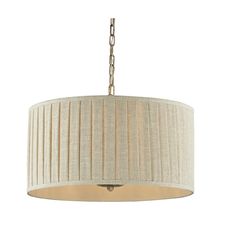 a chandelier hanging from the ceiling with a beige fabric shade on it and a gold chain