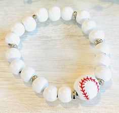 a white beaded bracelet with a baseball on it