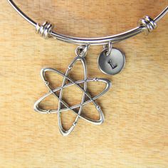 "♥ Silver Atom Charm Bangle Science Teacher Bracelet Atomic Symbol Gift Scientists Biology Researcher Chemistry Gift Personalized Gift ♥ This is a silver-tone Atom charm with hand stamped initial charm on an expandable bangle. ♥ You will receive 1 bangle ♥ Atom Charm 33(12/8\")x26(1\") mm. ♥ Initial charm stainless steel 10mm choose from a drop-down menu. ♥ Bangle 57-64 mm ♥ additional initial https://www.etsy.com/listing/766732811 ♥ We strive for next day shipping, but we do not ship on Saturda Silver Metal Friendship Bracelets, Silver Stainless Steel Friendship Jewelry, Modern Adjustable Nickel Free Charm Bracelet, Modern Adjustable Nickel-free Charm Bracelet, Silver Vintage Jewelry For Friendship, Antique Silver Nickel-free Charm Bracelet For Gift, Nickel-free Stainless Steel Bracelets For Jewelry Making, Personalized Silver Metal Bracelets, Antique Silver Charm Bracelet As Gift