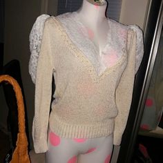 a female mannequin wearing a white sweater with pink polka dots on the bottom