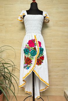 This beautiful dress is the perfect style to attend a Mexican party, with beautiful floral embroidery, has a spring at the waist to adjust the figure and a ducktail design. This dress is one size and fits S/M. Handcrafted machine embroidered dress. Each dress has unique embroidery so colors may vary. We ship anywhere in the word, from Tepic, Nayarit,  mx. Made by artisans from Oaxaca, Mx We recommend washing by hand with cold water, tender in the shade, to better preserve the original color. Fitted Dress With Embroidered Hem For Spring, Fitted High-low Midi Dress For Summer, Embroidered Midi Dress For Garden Party, Summer Embroidered Short Sleeve Maxi Dress, Floral Embroidered Knee-length Summer Dresses, Embroidered Short Sleeve Maxi Dress For Summer, Summer Embroidered Maxi Dress With Short Sleeves, Embroidered Maxi Dress For Summer Party, Fitted Floral Print Embroidered Dress For Summer