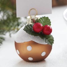 a christmas ornament with two cherries on it and a sign hanging from the top