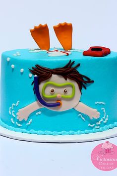 a blue cake decorated with an image of a boy swimming