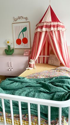 a child's bed with a red and white striped tent over the headboard