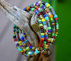 "This Gorgeous colorful beaded memory wire bracelet will always retain its shape & does not require any clasps - its so easy to get on & off the wrist! Just start at one end & wrap it around...it stays in place & couldn't be easier! Adorned with a wide variety of multi-colored Gemstone beads & Czech glass beads, the colors are fabulous! I've topped it off with cute brass charms at each end - a rustic bird on one end & a peace heart on the other...Very Boho Chic! Uniquely Brass Bird, Beaded Memory Wire Bracelets, Beaded Memory Wire, Project List, Memory Wire Bracelet, Rainbow Bracelet, Rainbow Beads, Memory Wire Bracelets, Boho Bracelet