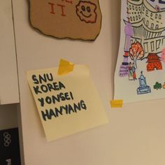 sticky notes attached to a refrigerator door with magnets on the wall and pictures above them