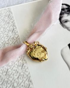 Cupid Locket Choker features a locket adorned with Cupid, a token of love. Comes with a pretty pink soft velvet ribbon. Spread love and style in one swoop! 18k Gold plated silver locket. Elegant Charms Locket Necklace For Mother's Day, Charm Pendant Locket Necklace For Wedding, Wedding Locket Necklace With Charms For Valentine's Day, Valentine's Day Wedding Locket Necklace With Charms, Elegant Wedding Locket Necklace With Charms, Elegant Vintage Charm Locket Necklace For Valentine's Day, Elegant Rose Gold Locket Necklace With Vintage Charm, Pink Charm Necklace For Wedding, Rose Gold Vintage Charm Locket Necklace For Wedding