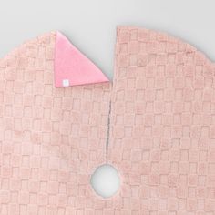 a close up of a piece of cloth with a hole in the middle that has a pink triangle on it