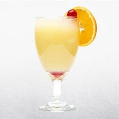 a glass filled with orange juice and garnished with an orange slice on the rim