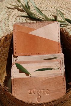 an open wallet sitting on top of a woven basket