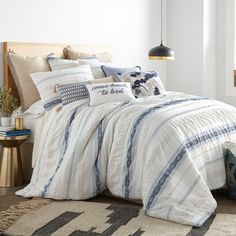 a bed with blue and white striped comforters