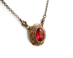 Beautiful victorian style pendant necklace made of a lovely oxidized brass filigree cabochon base, American made, and a vintage ruby red rhinestone cabochon. The size of the cabochon is 13 x 18 mm. The necklength is approximately 49 cm. (19.3 inches) For more jewelry please visit our shop: http://www.minouc.etsy.com For combined shipping please contact us. We also combine shipping with our other Etsy shop where we sell vintage fabrics and finds from Holland and France: http://www.minoucbrocante. Ornate Red Pendant Jewelry, Victorian Brass Necklace For Valentine's Day, Victorian Antique Gold Necklaces For Valentine's Day, Antique Red Necklace For Wedding, Victorian Antique Gold Necklace For Valentine's Day, Ornate Filigree Jewelry For Valentine's Day, Elegant Oval Pendant Necklace With Antique Finish, Victorian Red Jewelry With Vintage Charm, Victorian Style Brass Necklace With Oval Pendant