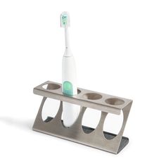 a toothbrush holder with three cups and a toothbrush in it on a white background