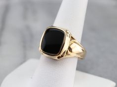 "This vintage men's ring is stylish black onyx and yellow gold, a combination that is sophisticated and traditional. The design of this ring offers a little more size and substance but is still easy to wear! Metal: 14K Yellow Gold Gem: Black Onyx Gem Measurements: 14.0 x 11.0 mm, Cushion Cut Ring Size: 13.75 Marks: \"14K\" Stamped on the inside band SKU #: F5C7A4R6 Each piece has been identified and graded by a Graduate Gemologist who has been certified by the Gemological Institute of America (G Black Cabochon Signet Ring For Formal Occasions, Formal Black Cabochon Signet Ring, Black Onyx Ring Men, Vintage Onyx Ring, Mens Vintage Jewelry, Onyx Ring Men, Retro Era, Cushion Cut Ring, Cameo Ring