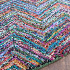 a multicolored area rug on top of a wooden floor