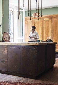 a woman sitting at a kitchen counter using her cell phone