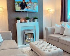 a living room filled with furniture and a flat screen tv mounted to the wall over a fire place