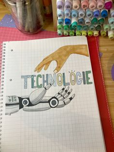 an open notebook with the words technology on it next to crayons and markers