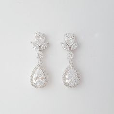 Crystal bridal earrings made with glittering halo set teardrop cubic zirconia crystals put onto cz detailed ear posts. The wedding earrings are also available in rose gold finish and 14k gold finish. Material used is rhodium plated brass components. Earrings are light weight and a great length. # length of Earring from top is approx. - 1 2/8 inches or 3.2 cms and 10 mm wide Please see link below for matching pieces. Emma Collection https://www.etsy.com/au/shop/poetryjewelry?ref=listing-shop-head Pear-shaped Diamond White Cluster Earrings For Wedding, Sparkling Diamond White Teardrop Bridal Earrings, Pear-shaped Halo Wedding Earrings, Pear-shaped Halo Design Wedding Earrings, Bridal Halo Design Cubic Zirconia Drop Earrings, Pear-shaped Diamond Earrings With Halo Setting For Wedding, Halo Design Cubic Zirconia Bridal Drop Earrings, Pear-shaped Cubic Zirconia Diamond Earrings For Wedding, Pear-shaped Teardrop Earrings With Halo Design For Wedding