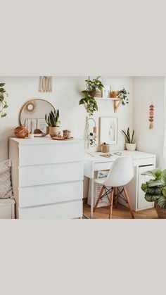 a room with white furniture and plants on the wall