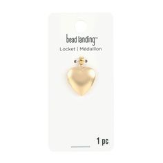 a gold heart shaped pin on a white card with the words bead landing in it