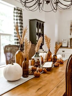 a wooden table topped with lots of bottles filled with pumpkins and other things on top of it