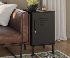 a living room with a brown leather chair and a black metal cabinet on the floor