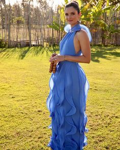 a woman in a blue dress standing on the grass