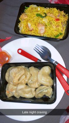 two trays filled with food sitting on top of a table