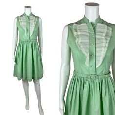 Vintage 1950s Mint Green Dress Women's Extra Small Sleeveless Ruffle Bib Belted Shirtdress You'll look as sweet as a scoop of mint ice cream in this darling 1950s shirt dress! This vintage beauty is a lovely shade of mint green with a white ruffle detail on the bodice, rhinestone buttons and a fitted waist with matching belt. Vintage dress zips up the side with a metal zipper. LABEL: - FABRIC: feels like cotton  MARKED VINTAGE SIZE: - SHOULDERS: 13.5" SHOULDER TO WAIST: 14.5" BUST: 35" WAIST: 26 1950s Style Sleeveless Green Dress, 1950s Vintage Summer Dress With Ruffles, 1950s Ruffled Vintage Dress For Spring, 1950s Vintage Ruffled Dress For Summer, 1950s Style Vintage Ruffled Dress For Summer, 1950s Style Sleeveless Spring Vintage Dress, 1950s Style Sleeveless Summer Vintage Dress, Summer Sleeveless Vintage 1950s Style Dress, Retro Sleeveless Vintage Dress With Ruffles